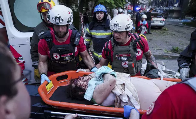 Red Cross volunteers evacuate an injured woman from a multi-storey residential house destroyed by a Russian strike in Kyiv, Ukraine, on Tuesday, June 17, 2025. (AP Photo/Evgeniy Maloletka)