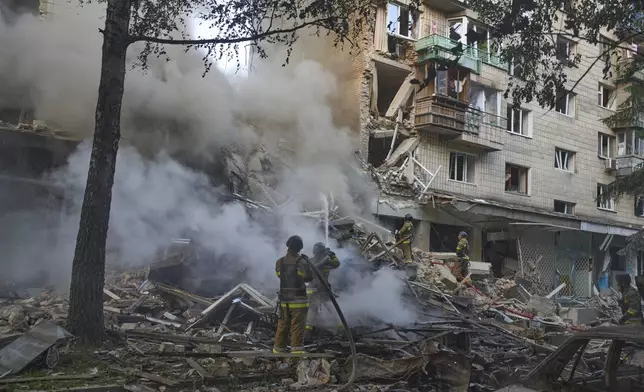 Firefighters put out the fire after a Russian missile hit a residential building during Russia's massive missile and drone air attack in Kyiv, Ukraine, Tuesday, June 17, 2025. (AP Photo/Efrem Lukatsky)
