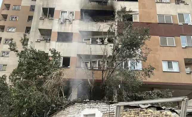 Firemen work at an apartment building after it was hit in Tehran, Iran, early Friday, June 13, 2025. Israel attacked Iran's capital early Friday, with explosions booming across Tehran.(AP Photo/Vahid Salemi)