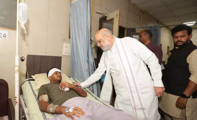 This handout photo issued by the Indian Ministry of Home Affairs shows Home Affairs Minister Amit Shah meeting British plane crash survivor Vishwash Kumar Ramesh, 40, at a hospital in Ahmedabad, after Air India confirmed Mr Ramesh was the sole survivor of the 242 people on board the London-bound Boeing 787 Dreamliner when it crashed into a medical college shortly after take-off from Ahmedabad airport. (Ministry of Home Affairs India via AP)