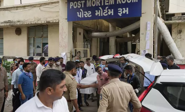 Volunteers and hospital staff carry a casket with a victim of the Air India plane crash out of the autopsy room at a hospital in Ahmedabad, India, Friday, June 13, 2025. (AP Photo/Rafiq Maqbool)