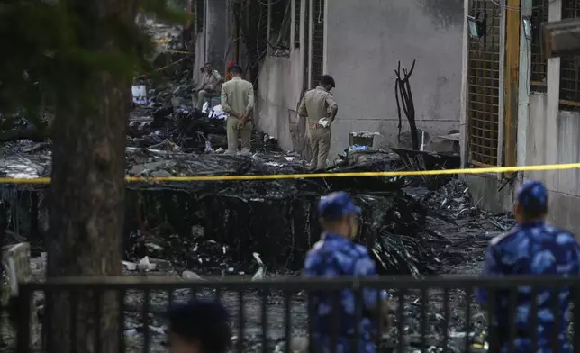 Policemen secure the site of an airplane crash in Ahmedabad, India, Friday, June 13, 2025. (AP Photo/Rafiq Maqbool)