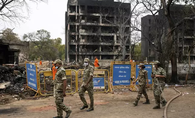 Security personnel patrol the site of an Air India plane crash in Ahmedabad, India, Friday, June 13, 2025. (AP Photo/Rafiq Maqbool)