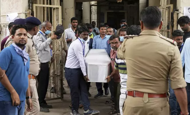 Health workers and volunteers carry the body of a victim of an airplane that crashed in India's northwestern city of Ahmedabad in Gujarat state, on Friday, June 13, 2025. (AP Photo/Ajit Solanki)