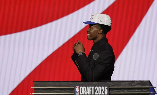 VJ Edgecombe walks across the stage after being selected third by the Philadelphia 76ers In the first round of the NBA basketball draft, Wednesday, June 25, 2025, in New York. (AP Photo/Adam Hunger)