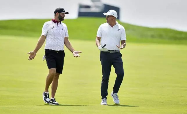 Dustin Johnson, left, and Phil Mickelson talk as they walk down the 12th fairway during a practice round ahead of the U.S. Open golf tournament at Oakmont Country Club Tuesday, June 10, 2025, in Oakmont, Pa. (AP Photo/Charlie Riedel)