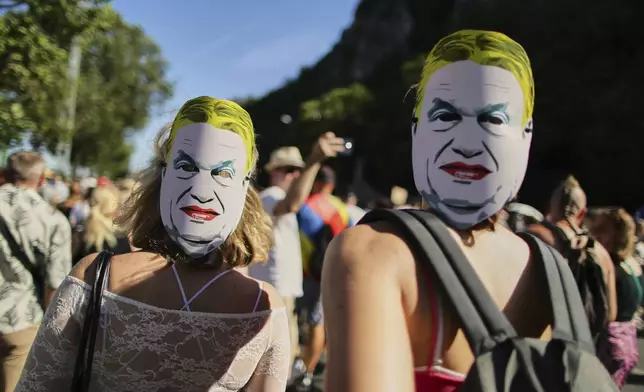 Participants in the Pride march wear masks depicting Hungarian Prime Minister Viktor Orban in Budapest, Hungary, Saturday, June 28, 2025. (AP Photo/Rudolf Karancsi)