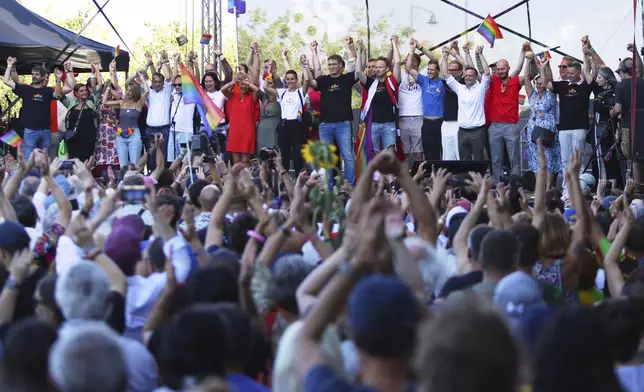 Budapest mayor Gergely Karacsony, center, holds his hands up along with European Union representatives during the Pride march in Budapest, Hungary, Saturday, June 28, 2025. (AP Photo/Rudolf Karancsi)