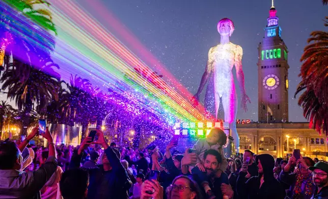 Rainbow lasers create a pride flag projected on Market Street from the Ferry Building during a ceremony for the 55th annual Pride Celebration in San Francisco on Friday, June 27, 2025. (Santiago Mejia/San Francisco Chronicle via AP)