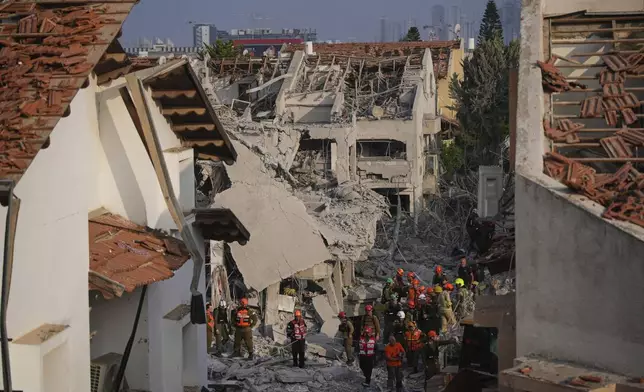 Israeli security forces inspect destroyed houses that were struck by a missile fired from Iran, in Rishon Lezion, Israel on Saturday, June 14, 2025. (AP Photo/Ohad Zwigenberg)