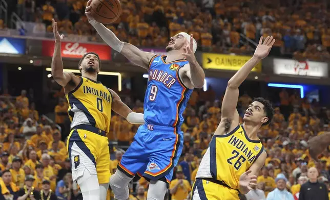 Oklahoma City Thunder guard Alex Caruso (9) shoots between Indiana Pacers guard Tyrese Haliburton (0) and guard Ben Sheppard (26) during the second half of Game 4 of the NBA Finals basketball series, Friday, June 13, 2025, in Indianapolis. (AP Photo/Michael Conroy)