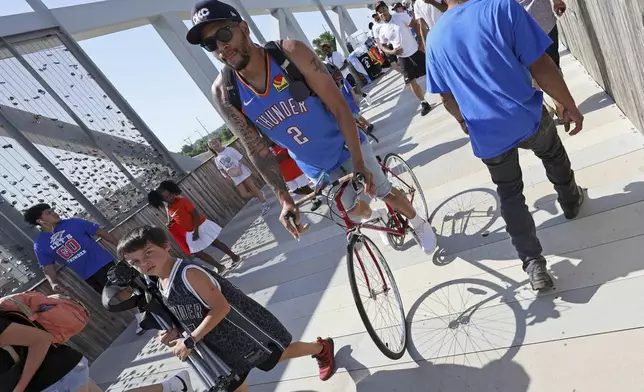 Fans make their way to the celebration of the Oklahoma City Thunder's NBA basketball championship Tuesday, June 24, 2025, in Oklahoma City. (AP Photo/Nate Billings)