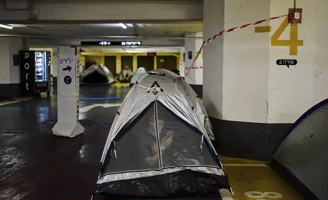 People shelter in an underground parking lot in Tel Aviv, Israel, Thursday, June 19, 2025. (AP Photo/Bernat Armangue)