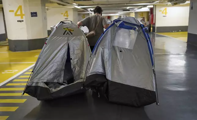 An Israeli woman packs tents in an underground parking garage used as a safety precaution against possible Iranian missile attacks in Tel Aviv, Israel, Wednesday, June 25, 2025. (AP Photo/Bernat Armangue)