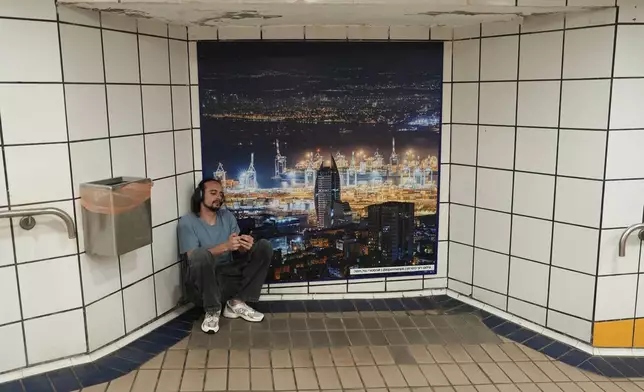 A man takes shelter in an underground metro station as air raid sirens warn of incoming Iranian strikes in Haifa, Israel, Tuesday, June 24, 2025. (AP Photo/Baz Ratner)