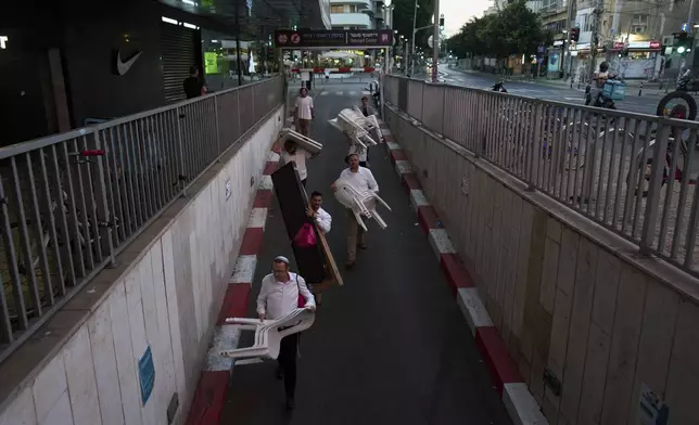 Jewish men walk into an underground parking lot for protection from potential missile attacks from Iran as they prepare to hold Sabbath prayer in Tel Aviv, Israel, Friday, June 20, 2025. (AP Photo/Bernat Armangue)