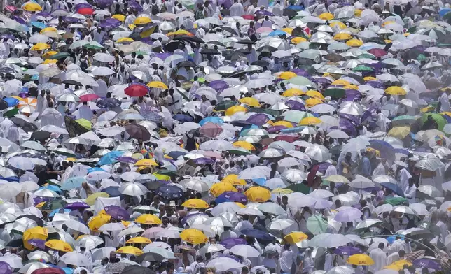 FILE - Muslim pilgrims use umbrellas to shield themselves from the sun as they gather outside Nimrah Mosque to offer the noon prayers in Arafat, on the second day of the annual hajj pilgrimage, near the holy city of Mecca, Saudi Arabia, Saturday, June 15, 2024. (AP Photo/Rafiq Maqbool, File)
