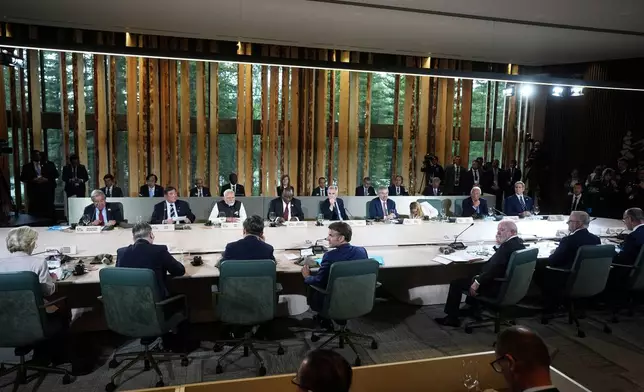 Canada's Prime Minister Mark Carney, back centre, chairs a meeting with world leaders and invited guests during the G7 Summit in Kananaskis, Alberta, Tuesday, June 17, 2025. (Darryl Dyck/The Canadian Press via AP)
