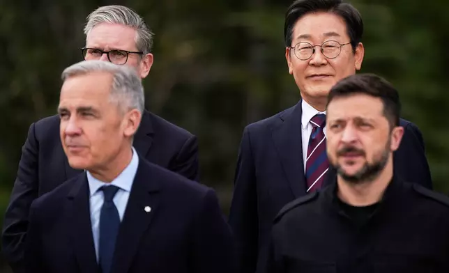 South Korean President Lee Jae-myung, back right, and Britain's Prime Minister Keir Starmer, back left, stand behind Canada's Prime Minister Mark Carney, front left, and Ukrainian President Volodymyr Zelensky, during the family photo during the G7 Summit in Kananaskis, Alberta, Tuesday, June 17, 2025. (Darryl Dyck/The Canadian Press via AP)