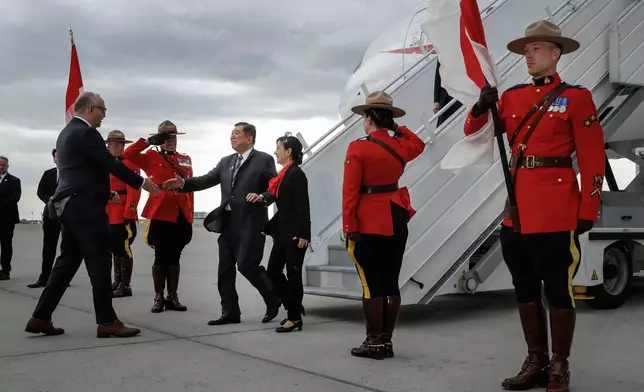 Japanese Prime Minister Shigeru Ishiba, centre, and his wife Yoshiko Ishiba are greeted as they arrive in Calgary, Alberta, Sunday, June 15, 2025, to attend the G7 Leaders meeting taking place in the nearby community of Kananaskis. (Jeff McIntosh/The Canadian Press via AP)