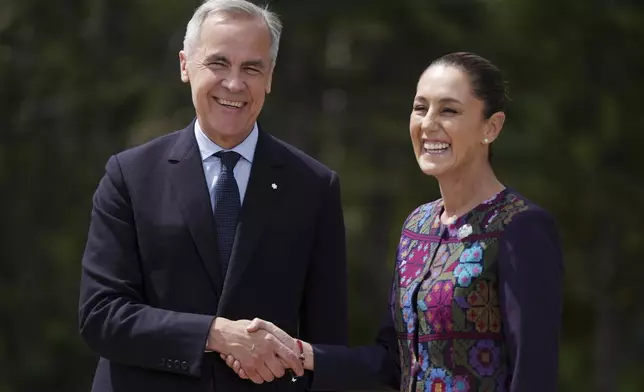 Canada's Prime Minister Mark Carney welcomes Mexican President Claudia Sheinbaum to the G7 Summit in Kananaskis, Alberta, Tuesday, June 17, 2025. (Darryl Dyck/The Canadian Press via AP)