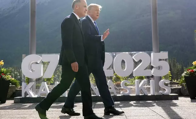 Canada's Prime Minister Mark Carney walks with President Donald Trump after a group photo at the G7 Summit, Monday, June 16, 2025, in Kananaskis, Canada. (AP Photo/Mark Schiefelbein)