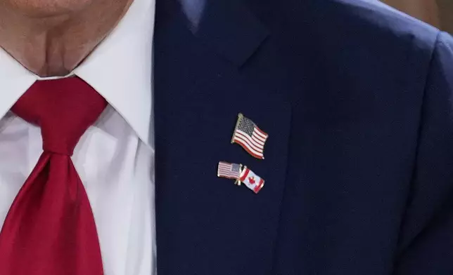 President Donald Trump wears a pin with the flags of Canada and the United States as he participates in a session of the G7 Summit, Monday, June 16, 2025, in Kananaskis, Canada. (AP Photo/Mark Schiefelbein)