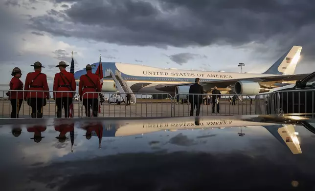 RCMP Mounties wait in front of Air Force One as President Donald Trump arrives in Calgary, Alberta, Sunday, June 15, 2025, to attend the G7 Leaders meeting taking place in Kananaskis, Alberta. (Jeff McIntosh/The Canadian Press via AP)