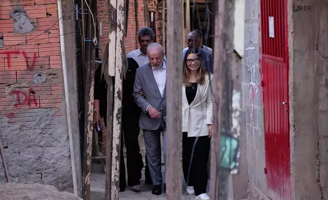 Brazil's President Luiz Inacio Lula da Silva and his wife Rosangela da Silva arrive to announce a housing program for the Moinho Favela, in Sao Paulo, Thursday, June, 26, 2025. (AP Photo/Ettore Chiereguini)