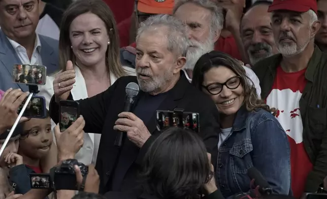 FILE - Brazil's former President Luiz Inacio Lula da Silva speaks to supporters accompanied by girlfriend Rosangela da Silva after he was released from Federal Police headquarters where he was imprisoned on corruption charges, in Curitiba, Brazil, Nov. 8, 2019. (AP Photo/Leo Correa, File)