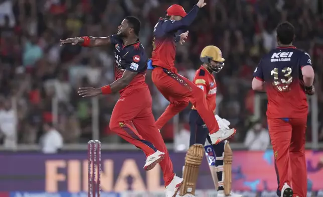 Royal Challengers Bengaluru's Romario Shepherd, left, and teammate Virat Kohli celebrate the dismissal of Punjab Kings' captain Shreyas Iyer, second right, during the Indian Premier League cricket final match between Punjab Kings and Royal Challengers Bengaluru at Narendra Modi Stadium in Ahmedabad, India, Tuesday, June 3, 2025. (AP Photo/Ajit Solanki)
