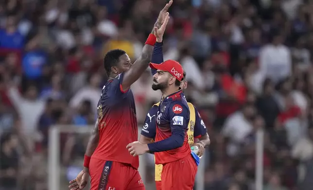 Royal Challengers Bengaluru's Romario Shepherd, left, and teammate Virat Kohli celebrate the dismissal of Punjab Kings' captain Shreyas Iyer during the Indian Premier League cricket final match between Punjab Kings and Royal Challengers Bengaluru at Narendra Modi Stadium in Ahmedabad, India, Tuesday, June 3, 2025. (AP Photo/Ajit Solanki)