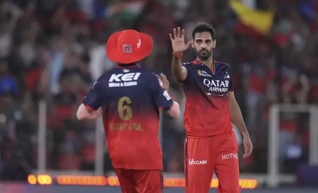 Royal Challengers Bengaluru's Bhuvneshwar Kumar, right, celebrates the wicket of Punjab Kings' Nehal Wadhera with Kunal Pandya during the Indian Premier League final cricket match between Punjab Kings and Royal Challengers Bengaluru at Narendra Modi Stadium in Ahmedabad, India, Tuesday, June 3, 2025. (AP Photo/Ajit Solanki)