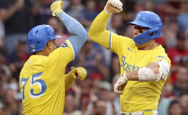 Boston Red Sox's Romy Gonzalez, right, and teammate Carlos Narváez, left, celebrate Gonzalez's home run during the seventh inning of a baseball game against the Toronto Blue Jays, Saturday, June 28, 2025, in Boston. (AP Photo/Mark Stockwell)