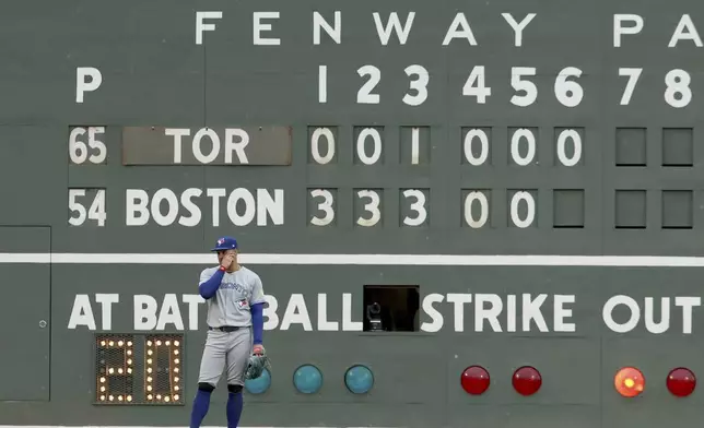 Toronto Blue Jays outfielder George Springer stands in front of the scoreboard during the sixth inning of a baseball game against the Boston Red Sox, Saturday, June 28, 2025, in Boston. (AP Photo/Mark Stockwell)