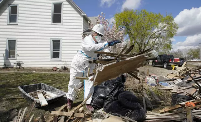 FILE - A volunteer with Team Rubicon discards flood-damaged materials from a house in Pacific Junction, Iowa, April 18, 2019. (AP Photo/Nati Harnik, File)
