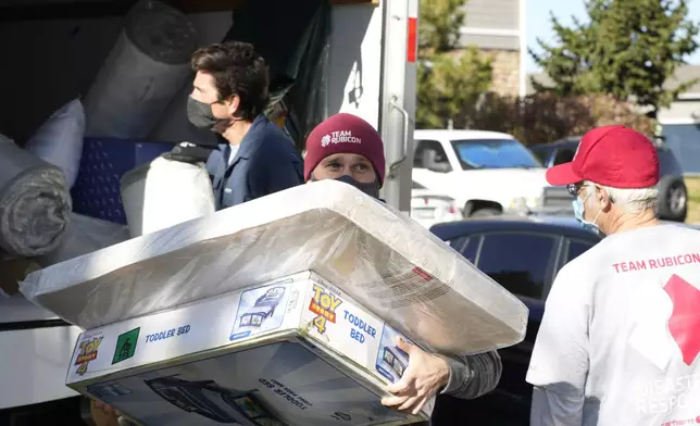 FILE - Team Rubicon volunteer Nicholas Duchnowski of Broomfield, Colo., moves belongings into an apartment that will be home to Afghan refugees, in the north Denver suburb of Thornton, Colo., Nov. 10, 2021. (AP Photo/David Zalubowski, Filepronto)