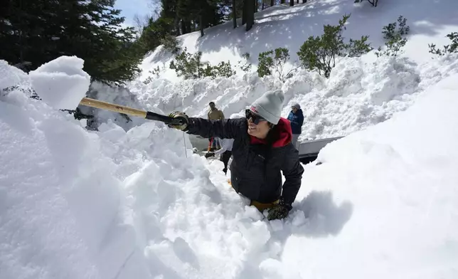 FILE - Monica Tapia, a volunteer with the disaster response group Team Rubicon, digs a resident's vehicle out of the snow, in Lake Arrowhead, Calif., March 8, 2023. (AP Photo/Marcio Jose Sanchez, File)