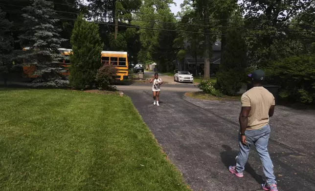 Evan Polk, right, walks to greet his daughter, Jordyn Polk, 13, from the bus after school in Secane, Pa., Thursday, June 5, 2025. (AP Photo/Matt Slocum)
