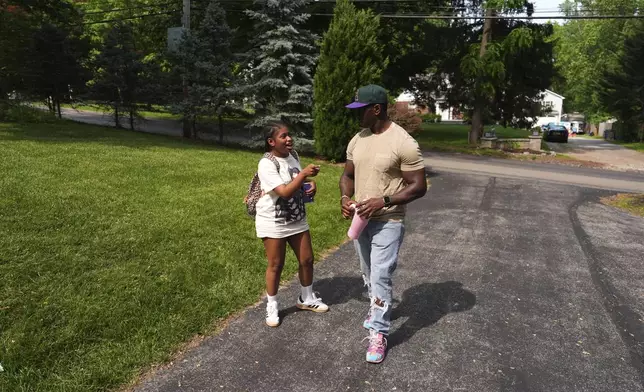 Evan Polk, right, talks with his daughter, Jordyn Polk, 13, after she was dropped off from school in Secane, Pa., Thursday, June 5, 2025. (AP Photo/Matt Slocum)