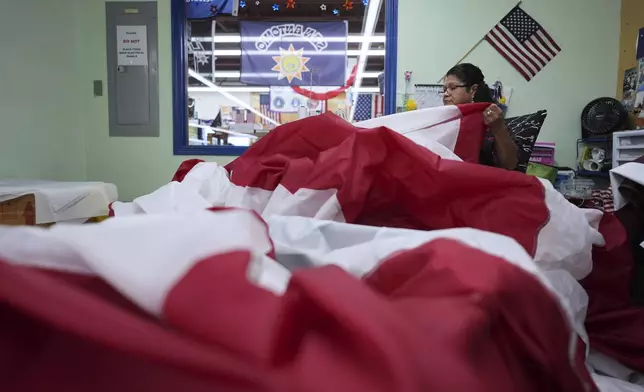 Lucy A. Rodriguez sews the stripes for a large U.S. flag at Dixie Flag and Banner, Tuesday, June 10, 2025, in San Antonio. (AP Photo/Eric Gay)