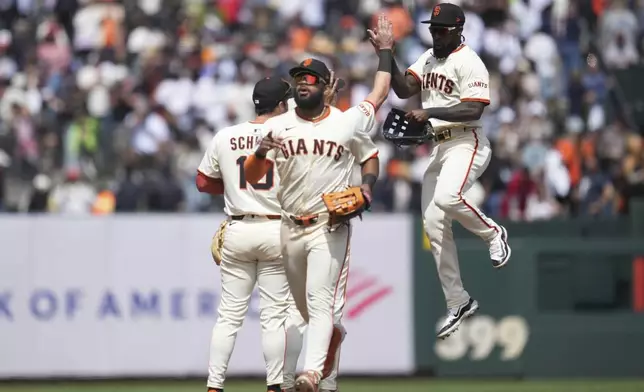 San Francisco Giants' Heliot Ramos, foreground, celebrates with Casey Schmitt, left, and Daniel Johnson after a baseball game against the Atlanta Braves in San Francisco, Sunday, June 8, 2025. (AP Photo/Jeff Chiu)