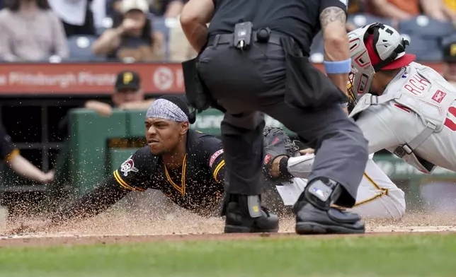 Pittsburgh Pirates' Ke'Bryan Hayes, left, scores as Philadelphia Phillies catcher Rafael Marchan, right, applies the late tag during the second inning of a baseball game Sunday, June 8, 2025, in Pittsburgh. (AP Photo/Matt Freed)