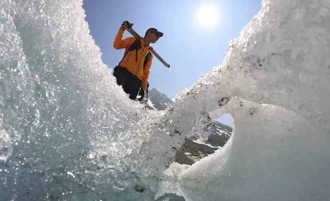 Matthias Huss, of the Federal Institute of Technology in Zurich and glacier monitoring group GLAMOS, stands at the Rhone Glacier near Goms, Switzerland, June 10, 2025. (AP Photo/Matthias Schrader)
