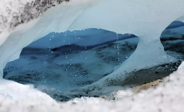 Water drips from a melting chunk of ice that originated from the Rhone glacier near Goms, Switzerland, June 10, 2025. (AP Photo/Matthias Schrader)