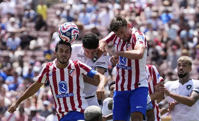 Atletico Madrid's Koke, left, and Clement Lenglet, right, go for a header with Botafogo's Jair Cunha during the Club World Cup Group B soccer match between Atletico Madrid and Botafogo in Pasadena, Calif., Monday, June 23, 2025. (AP Photo/Gregory Bull)