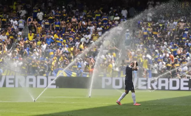 Auckland City's Gerard Garriga cools off under the sprinklers during a water break in the Club World Cup Group C soccer match between Auckland City and Boca Juniors in Nashville, Tenn., Tuesday, June 24, 2025. (AP Photo/George Walker IV)