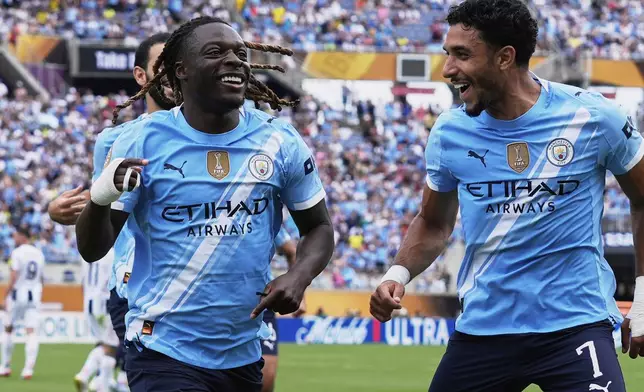 Manchester City's Jeremy Doku, left, celebrates after scoring the opening goal during the Club World Cup Group G soccer match between Juventus and Manchester City in Orlando, Fla., Thursday, June 26, 2025. (AP Photo/John Raoux)