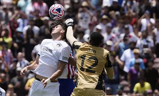 Botafogo's John, right, and teammate Jair Cunha jump for the ball during the Club World Cup Group B soccer match between Atletico Madrid and Botafogo in Pasadena, Calif., Monday, June 23, 2025. (AP Photo/Gregory Bull)