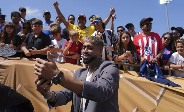 Botafogo's Alexander Barboza poses for a selfie photo with fans prior to the Club World Cup Group B soccer match between Atletico Madrid and Botafogo in Pasadena, Calif., Monday, June 23, 2025. (AP Photo/Jae Hong)